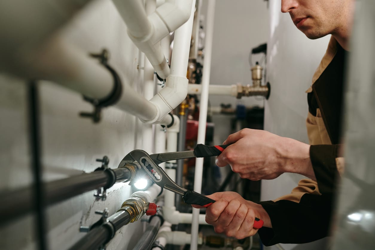 Plumbers maintaining commercial plumbing pipes in New Castle