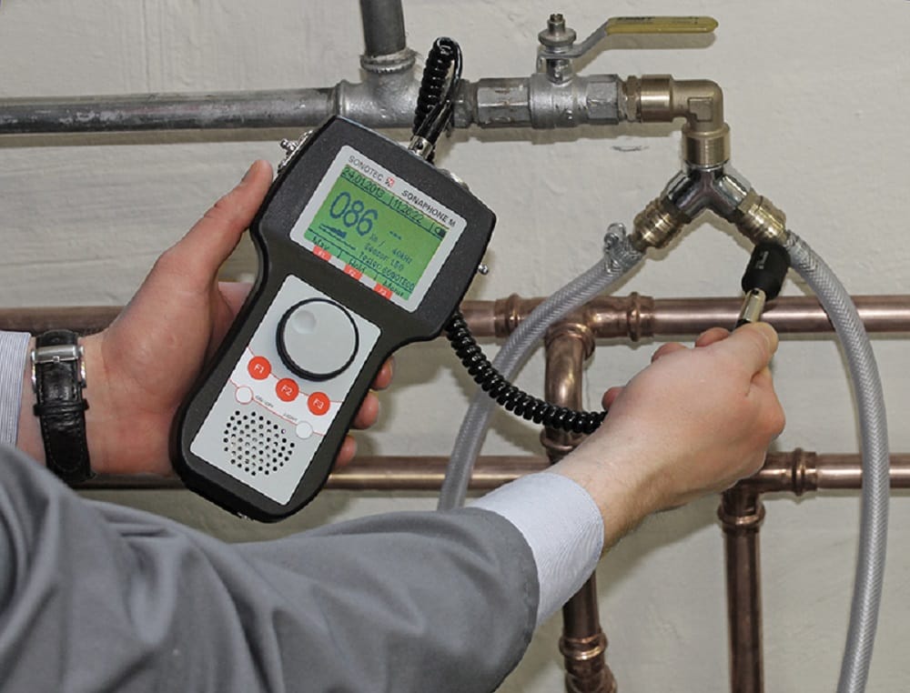 Plumber testing pipes with electronic leak detection equipment in New Castle