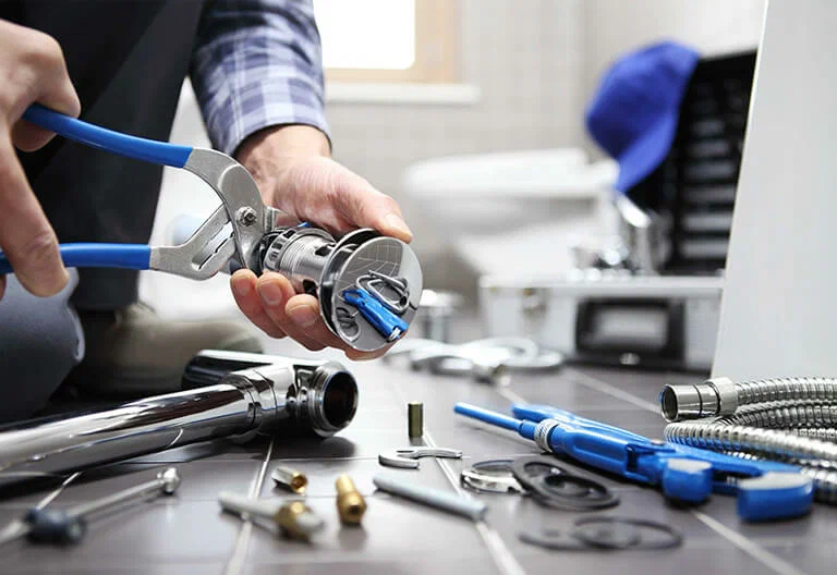 Technician repairing a plumbing fixture with professional tools in New Castle