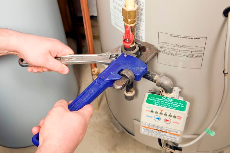 Plumber repairing a water heater valve in New Castle